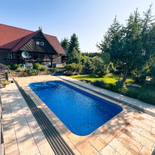 Zahradní bazén Havai se zaoblenými rohy na stinné zahradě.