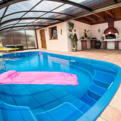 Bazén Malorka spojený s terasou a plovoucí růžové lehátko.